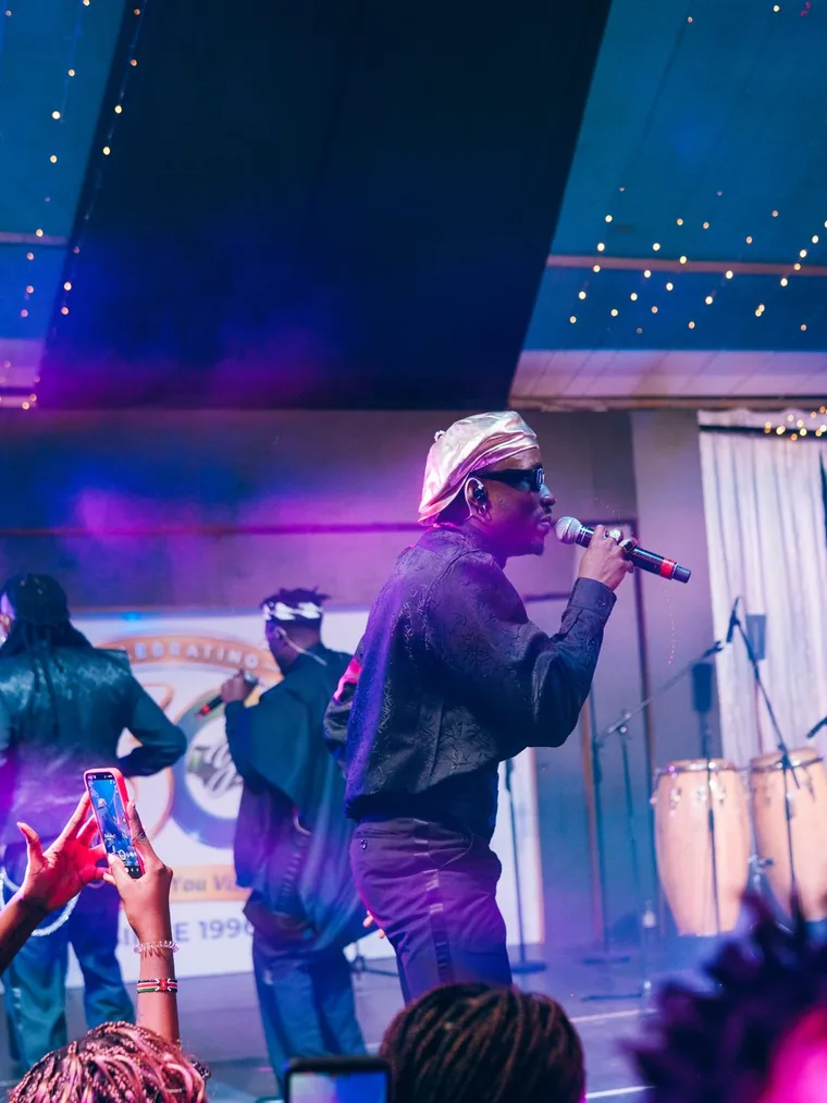 Kodong Klan performing with the band under purple light.