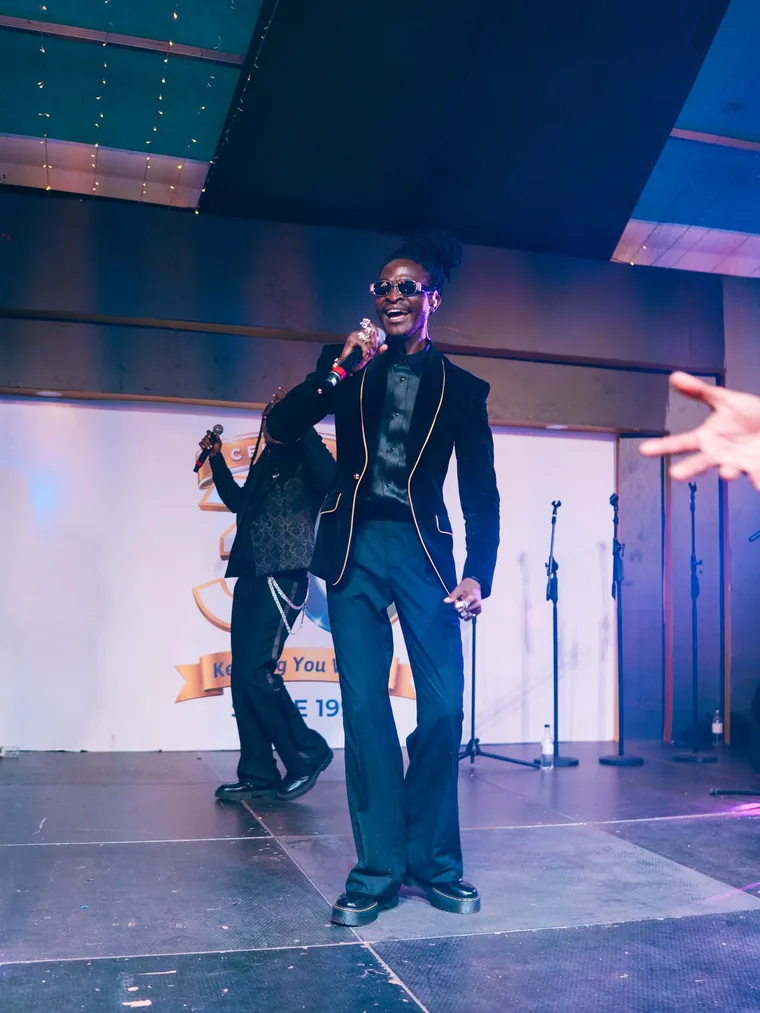 Kodong Klan vocalist in a velvet jacket performing.
